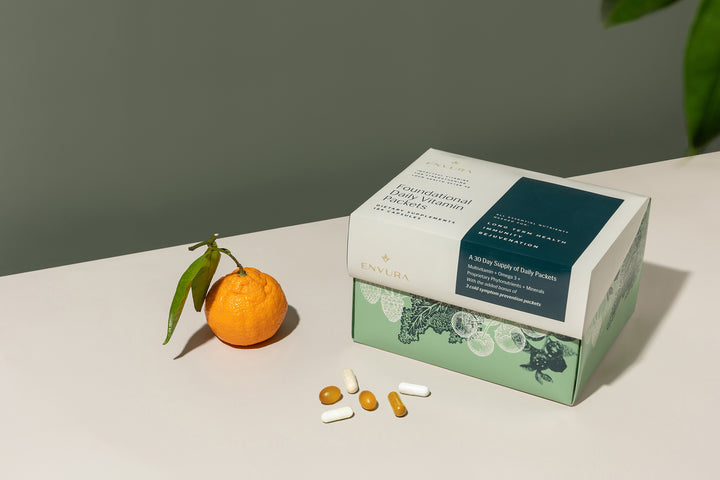 vitamin box, vitamins, and an orange on a table